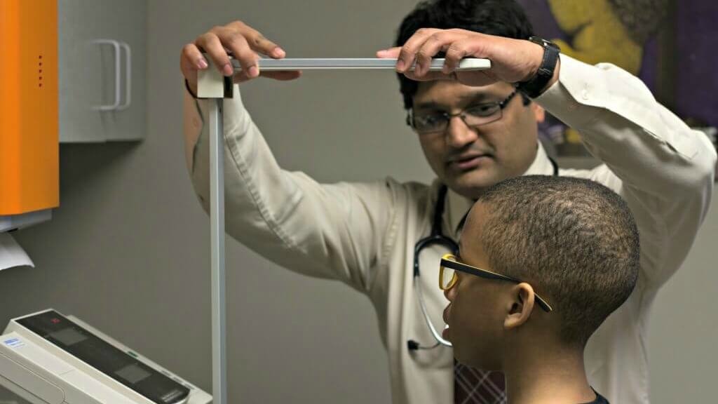 Dr. Mauj Goel measures a young patient at the Beloit Area Community Health Center